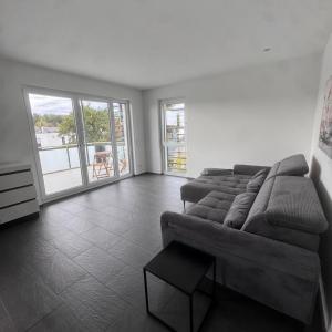 a living room with a couch and a large window at Exclusives 3 Zimmer Apartment in Zimmern ob Rottweil