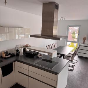 a kitchen with a black counter top and a table at Exclusives 3 Zimmer Apartment in Zimmern ob Rottweil