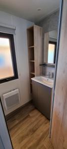 a small bathroom with a sink and a window at Mobil Home 45 m2 très luxueux 3 ch et 2 sdb - Camping 4 étoiles Les Charmettes 499 PROCHE FUN ZONE- Les Mathes in Les Mathes