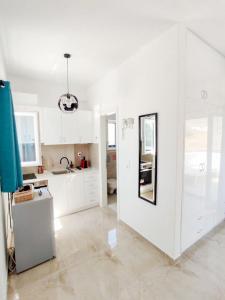 a kitchen with white cabinets and a sink at Nympes Melody - Golden Harmony Stay in Parasporos