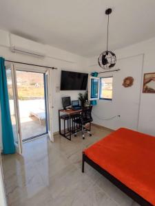 a living room with a desk and a bed and a computer at Nympes Melody - Golden Harmony Stay in Parasporos
