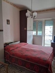 a bedroom with a red bed and a window at appartamento con balcone in Carpineto Romano
