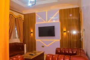 a living room with two leather couches and a television at D&G Hotels & Suites in Agege