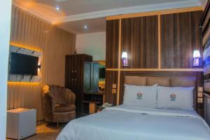 a hotel room with a bed and a chair at D&G Hotels & Suites in Agege