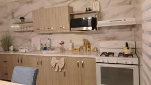 una cocina con estufa y microondas en Villa Fina Aruba, en Palm-Eagle Beach