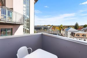 Una silla blanca en un balcón con vista. en Mitten in Kempten - Großzügig - Tolles Design, en Kempten