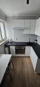 a kitchen with white cabinets and a black counter top at Apartament przy Starym Rynku in Poznań