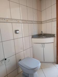 a bathroom with a toilet and a sink at Sobrado Mãezinha Aparecida in Aparecida