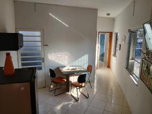 a dining room with a table and two chairs at Sobrado Mãezinha Aparecida in Aparecida
