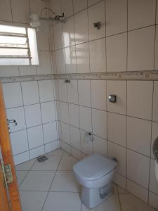 a bathroom with a white toilet and a window at Sobrado Mãezinha Aparecida in Aparecida +15 photos