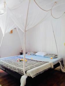 a bed with a white canopy in a room at Casa Madro in Malindi +18 photos