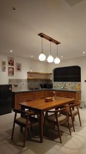 a kitchen with a wooden table and some lights at Bukti Garden Villas in Bukti