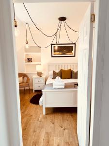 a bedroom with a white bed and a couch at Kinnoull House near Stornoway Hot-Tub Sauna Pet Friendly in Garrabost