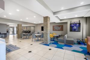 a lobby with tables and chairs in a building at Microtel Inn & Suites By Wyndham Conway in Conway