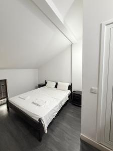 a white room with a bed with white sheets and pillows at Restaurant-Motel Khan Krum in Kamchiya