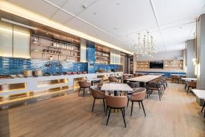 Un restaurante con mesas y sillas y una cocina. en Meipeng Light Luxury-Olympic Sports Center International Financial City Store, en Guangzhou 42 fotos más