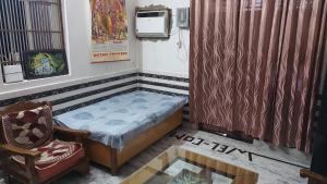 a small room with a bed and a chair at Radha Ras Homestay in Barsāna