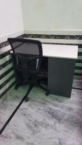 a desk and a chair in a room at Radha Ras Homestay in Barsāna +2 photos