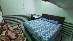 a small bedroom with a bed in a room at Radha Ras Homestay in Barsāna