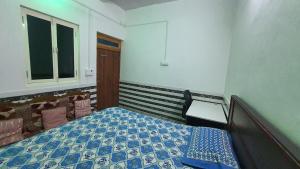 a small bedroom with a bed and a window at Radha Ras Homestay in Barsāna