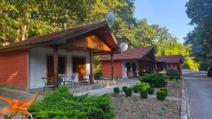 a small red and white building with tables and chairs at Restaurant-Motel Khan Krum in Kamchiya