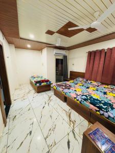 two beds in a room with a marble floor at Hotel Shree Siddhi vinayak in Ujjain