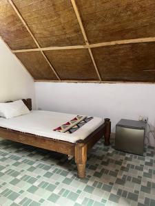a bed in a room with a wooden ceiling at Olga Beach Nungwi in Nungwi