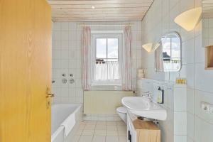 a bathroom with a tub and a sink and a bath tub at Kuschelige Ferienwohnung mit Balkon & Free Wifi in Buchenberg +18 photos