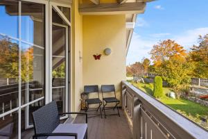 a balcony with chairs and a view of a yard at Kuschelige Ferienwohnung mit Balkon & Free Wifi in Buchenberg