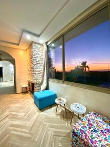 a living room with a large window and a couch at Room 3 villa Sunset Moulay Bouzerktoun in Essaouira