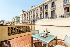 een tafel met twee glazen wijn op een balkon bij Exe Ramblas Boquería in Barcelona