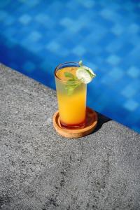 a drink sitting on a table next to a pool at Villa Lumbung Sidemen in Sidemen