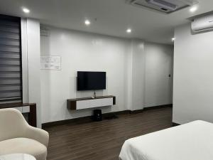 a room with a bed and a tv on a wall at Elegant Hotel in Hanoi