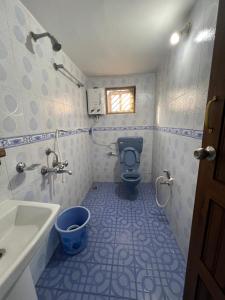 a bathroom with a toilet and a sink at House of Raj in Madikeri