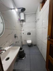 a white bathroom with a sink and a toilet at House of Raj in Madikeri +6 photos