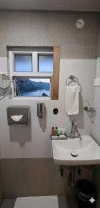 a bathroom with a white sink and a window at Hotel SVA in Sitam Petta