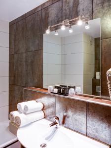 a bathroom with a sink and a mirror at Hotel Moers van der Valk in Moers