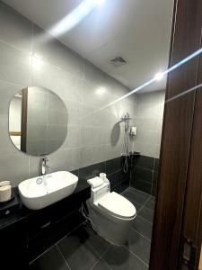 a bathroom with a sink and a toilet and a mirror at Elegant Hotel in Hanoi