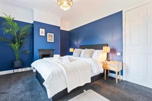 a blue bedroom with a large bed and a blue wall at Haven on the Hill - FREE Parking & Great for Groups in Abertillery