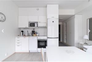 a white kitchen with white cabinets and a refrigerator at Scandic Nest in Jyväskylä