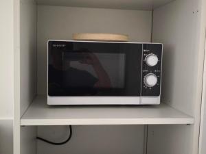 a microwave on a shelf with a person taking a picture at Chez Mimi in Beaurepaire
