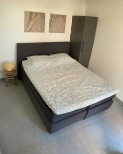 a bed in a room with a bed frame at Nieuw Studio 16 met uitzicht op Domburg in Aagtekerke