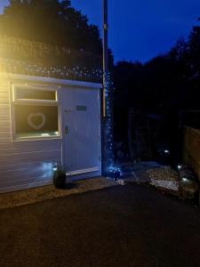 een witte garage met verlichting aan de zijkant van een huis bij 'Little Star' accommodation in Heathfield