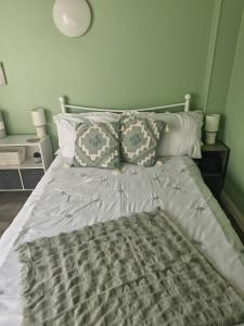 een bed met een dekbed en kussens in een slaapkamer bij 'Little Star' accommodation in Heathfield