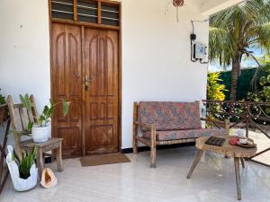 a porch with a couch and a wooden door at Outdoor Cinema Group Friendly Retreat in Pingwe