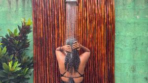 a man with long hair is in a shower at Outdoor Cinema Group Friendly Retreat in Pingwe
