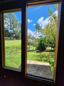 a window with a view of a field at Casa Pessegueiro in Urubici