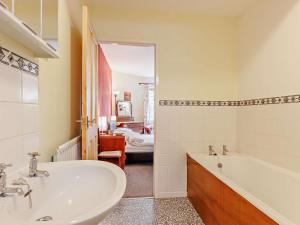 a bathroom with a sink and a tub and a bed at 3 Bed in Machynlleth 93080 in Cemmaes