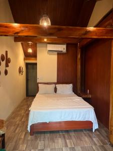 ein Bett in einem Zimmer mit Holzdecke in der Unterkunft Phong Nha Coco House in Phong Nha