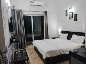 Postel nebo postele na pokoji v ubytování Pearl suites at omaxe eternity near prem mandir